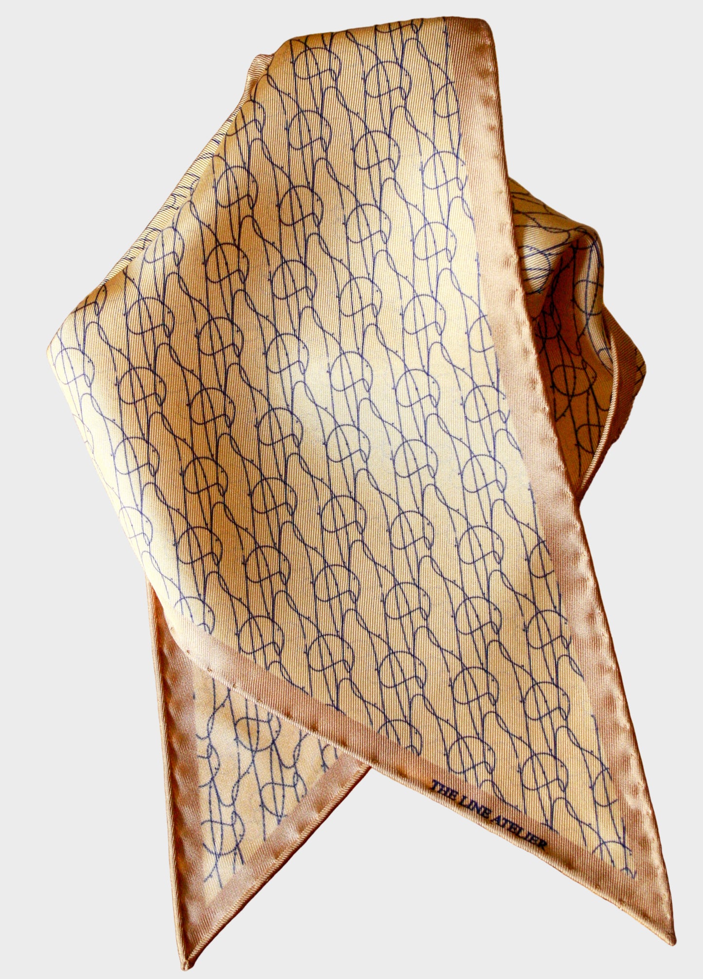 Rogue Of The Sands silk diamond sized scarf in golden tan with abstract blue pattern by The Line Atelier