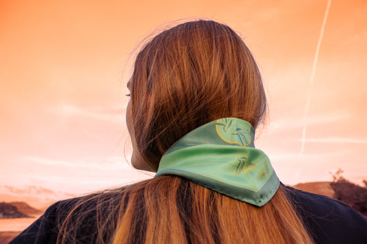 Model wearing Rogues Compass by The Line Atelier green silk scarf diamond size with swallows is gold lineart