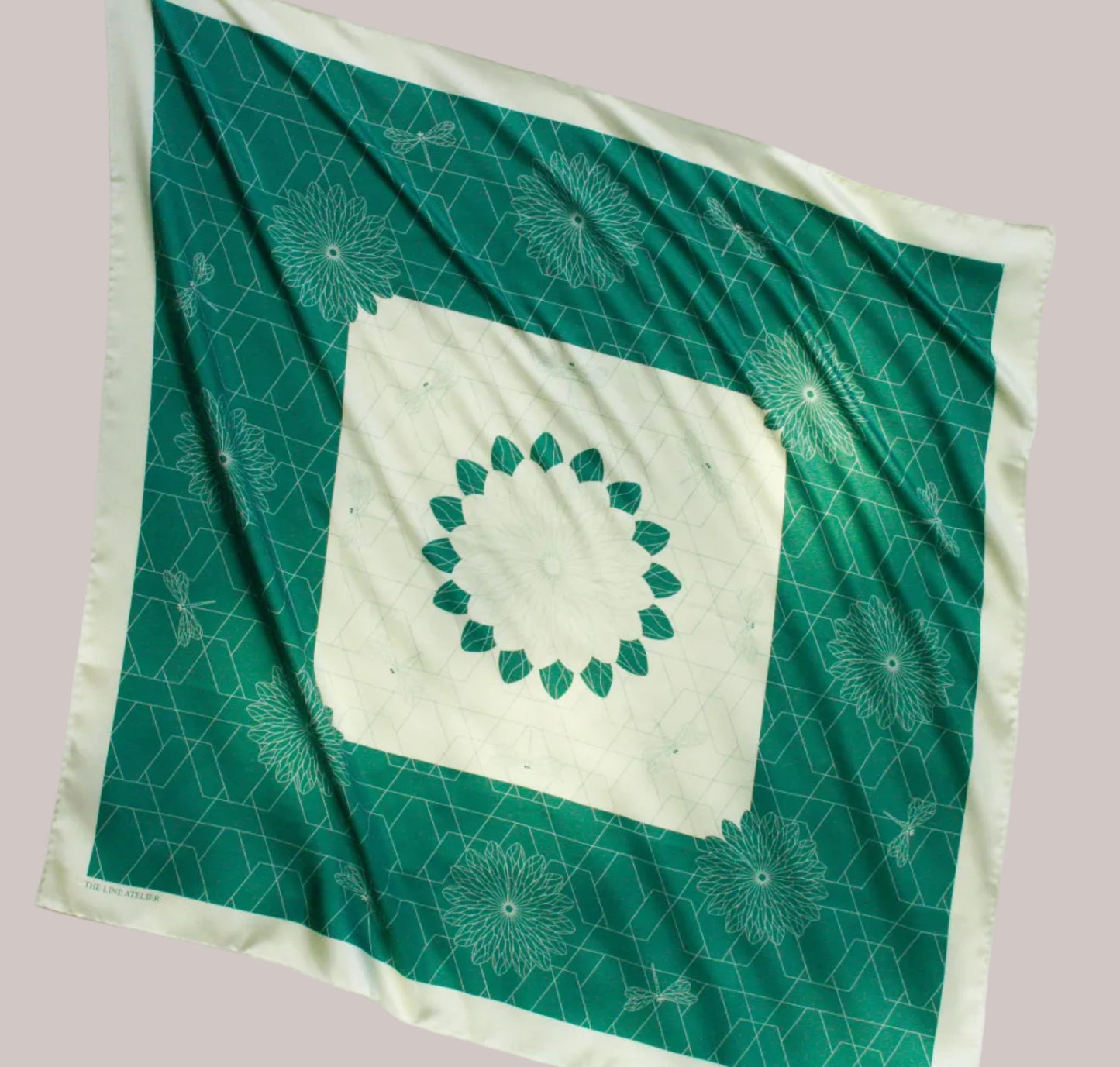 Green and white patterned silk scarf with a central design on a white background