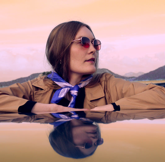 Model wearing 60cm square silk scarf with blue border and circular design