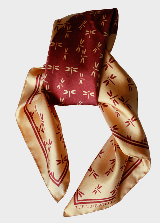 Red and gold patterned silk scarf on a beige background