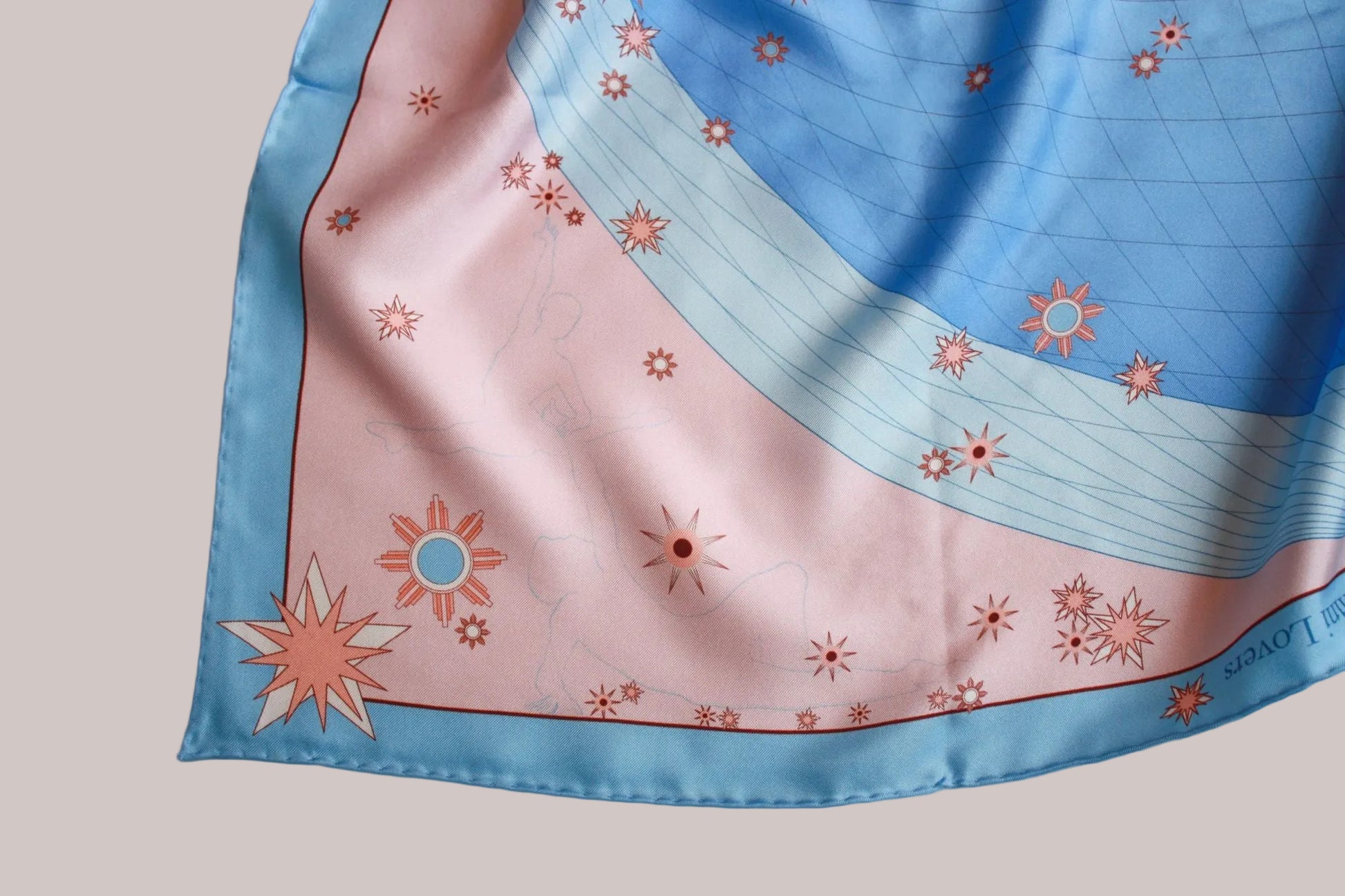 A square silk scarf with a celestial pattern, featuring a light blue border, a pink lower section with sun motifs, and a blue upper section with grid lines and stars. A line art illustration of a pair of ballerinas posing together.