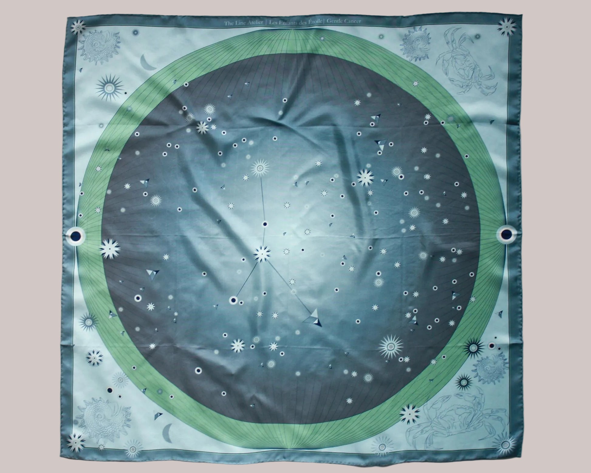A square scarf featuring a celestial design of the cancer constellation in shades of green and, smokey blue and grey silk. 