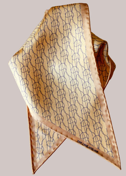 Rogue Of The Sands silk diamond sized scarf in golden tan with abstract blue pattern by The Line Atelier