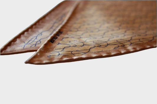 Camel silk diamond scarf with blue patterns on a gray background