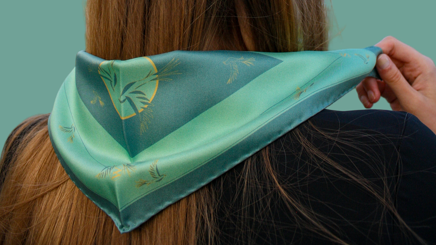 Model wearing Rogues Compass by The Line Atelier green silk scarf diamond size with swallows is gold lineart