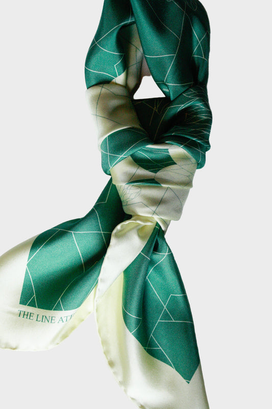 Green and white patterned silk scarf on a white background