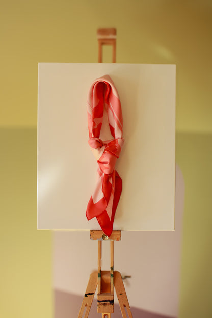 Rose d`Amour silk scarf on a wooden easel against a green wall