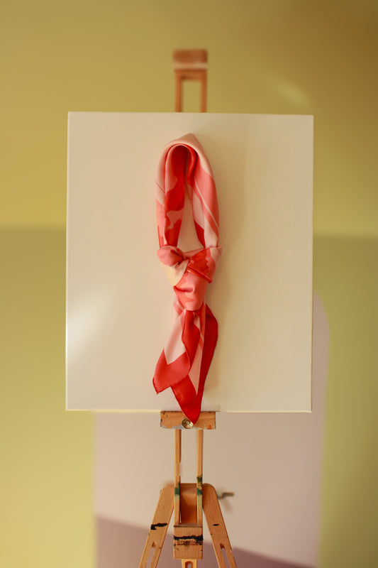 Rose d`Amour silk scarf on a wooden easel against a green wall
