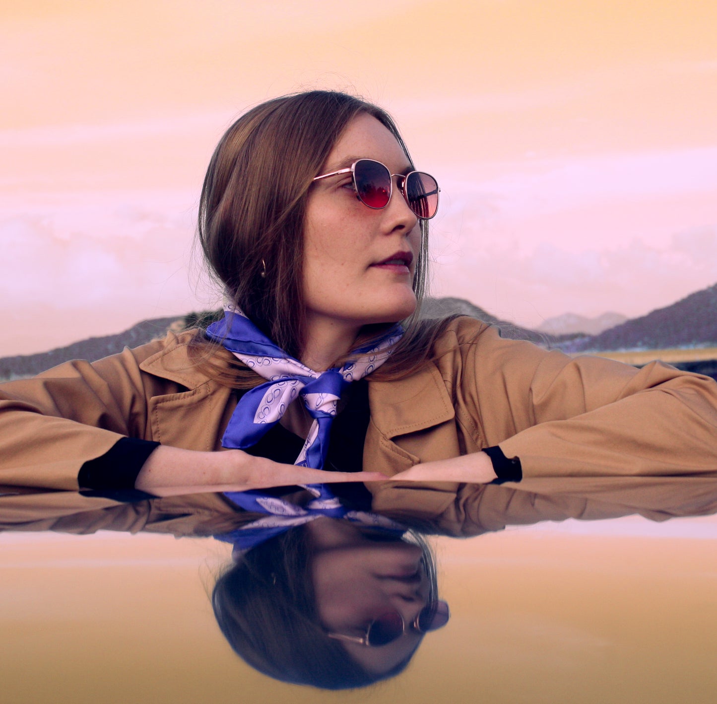 Model wearing 60cm square silk scarf with blue border and circular design